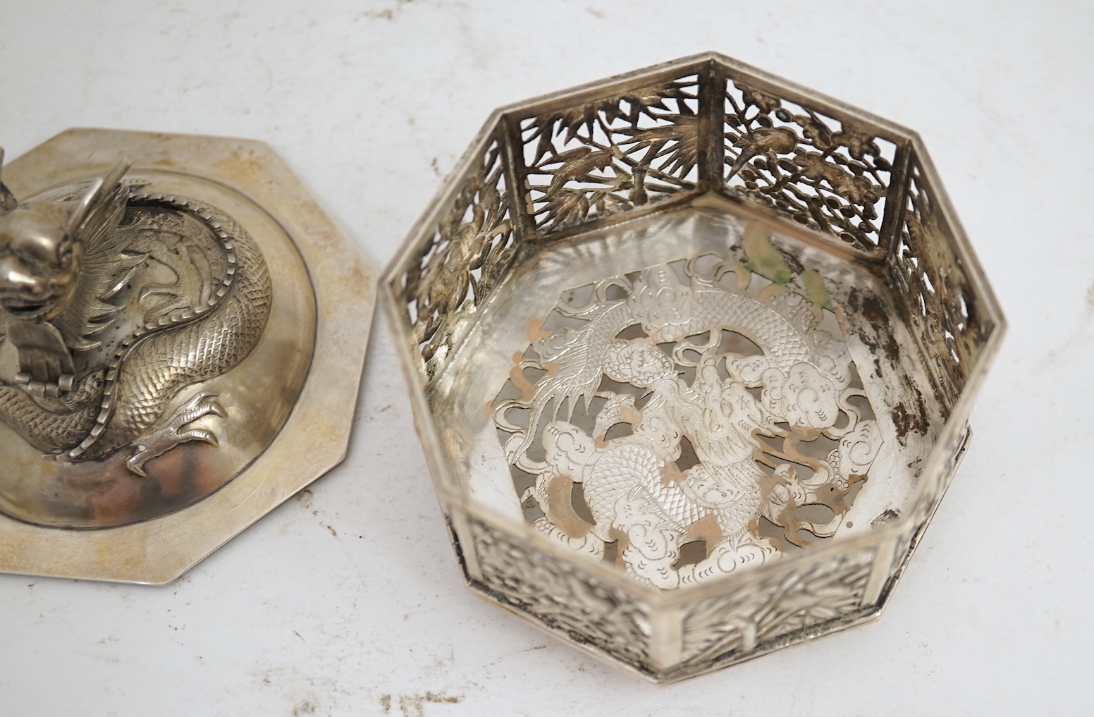 A late 19th century Chinese Export pierced silver card case, maker KMS(Kwong Man Shing), decorated with dragons amid clouds, 10.4cm, together with a Chinese Export pierced silver octagonal box and cover, by Luen Wo?, cir